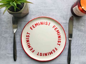 A white plate with a red inscription Feminist
