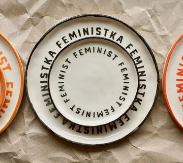 A white plate with a black inscription Feministka