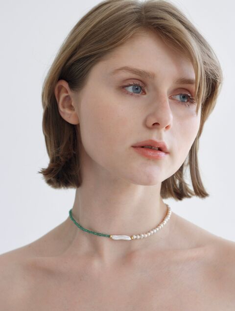 Necklace of pearls and small green stones with a rectangular pearl