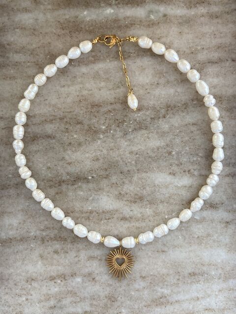 A pearl necklace with a golden heart
