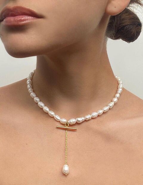 A pearl necklace with a pendant in the middle