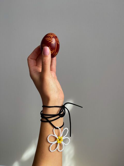 Біла квітка на чорному шнурку