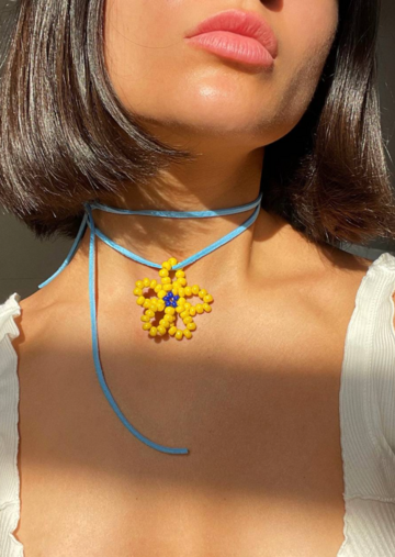 A yellow flower on a blue string