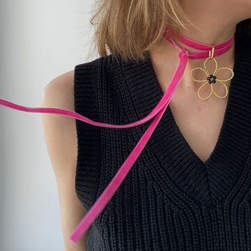 Золота квітка на рожевій стрічці