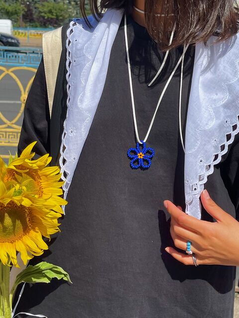 Синя квітка на білому шнурку