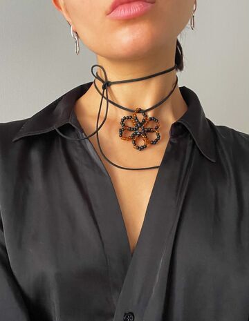 A black and brown flower on a black string