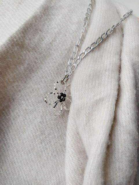 Срібна квітка з чорною серединкою на ланцюгу