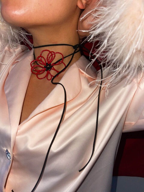 Червона квітка на чорному шнурку