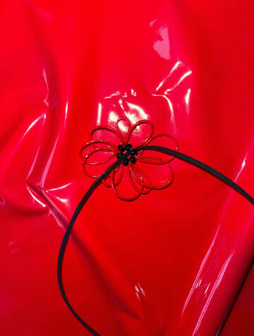 Червона квітка на чорному шнурку