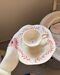 Set of cup and saucer with red branches
