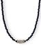 Choker with black stones and a white quartz bead in the center