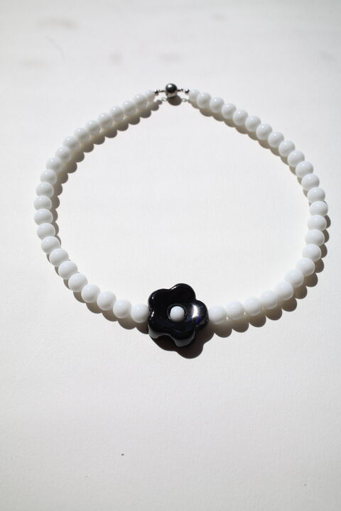 Choker Daisy with a black flower on a white base