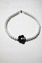 Choker Daisy with a black flower on a white base